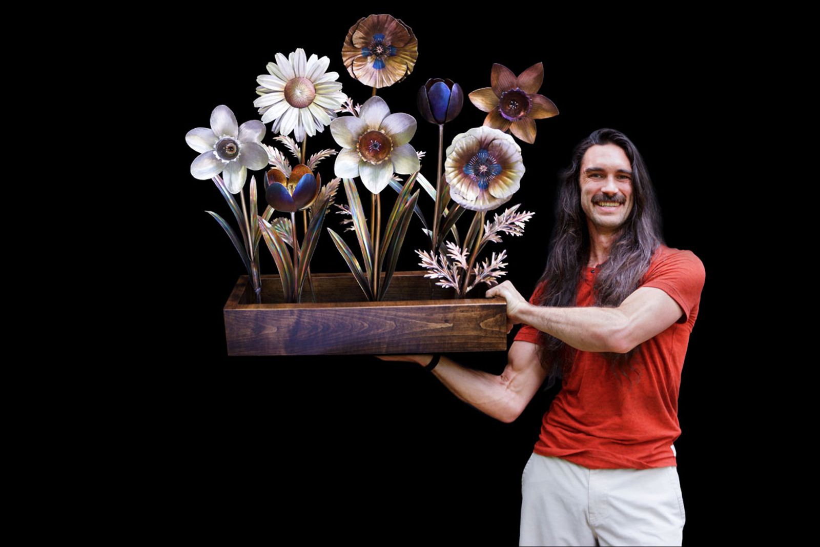 Artist Aiden Dale with his oversized stainless steel flower planter sculpture, a larger-than-life bouquet of flame-painted metal blooms.