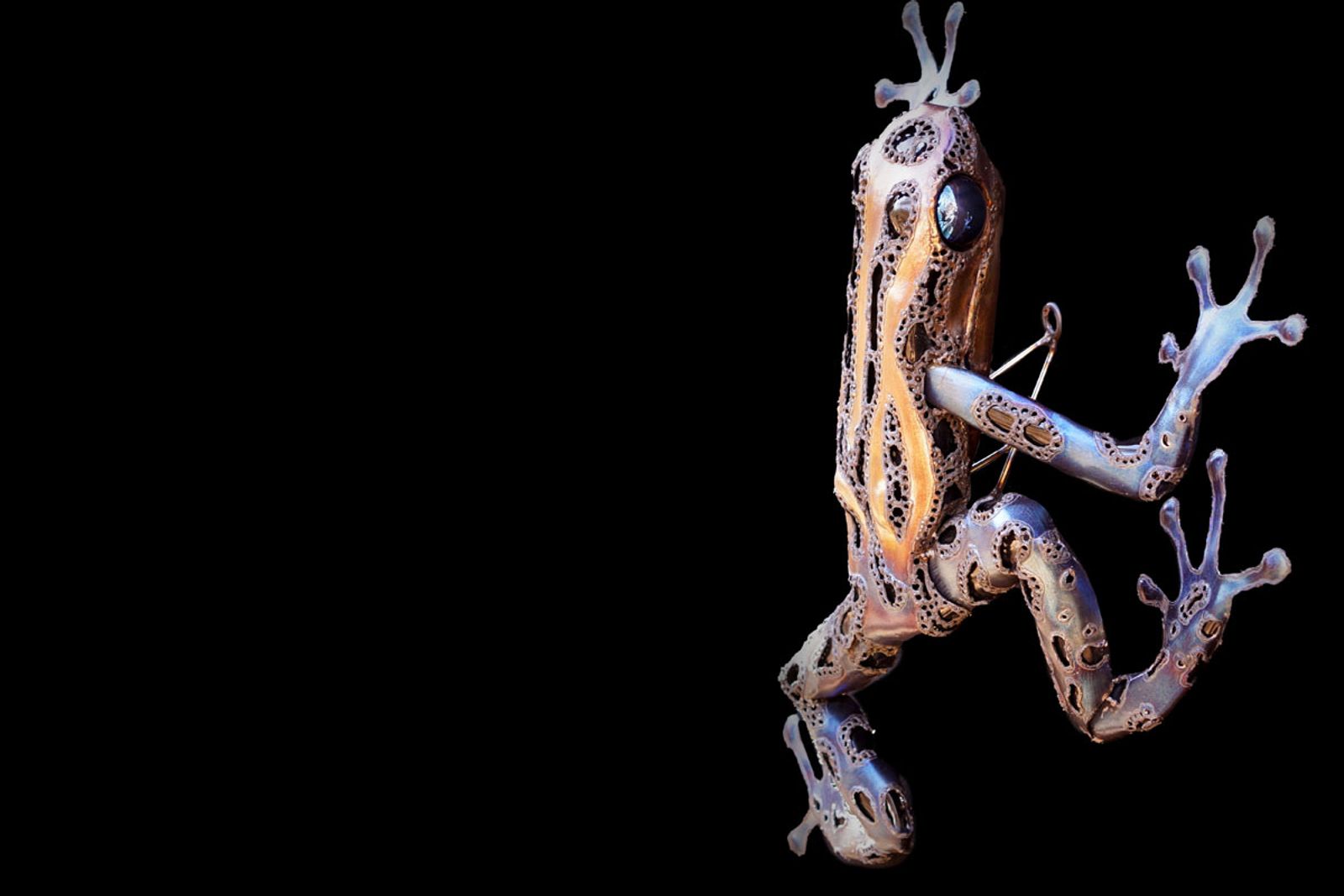 Side view of stainless steel poison dart frog sculpture