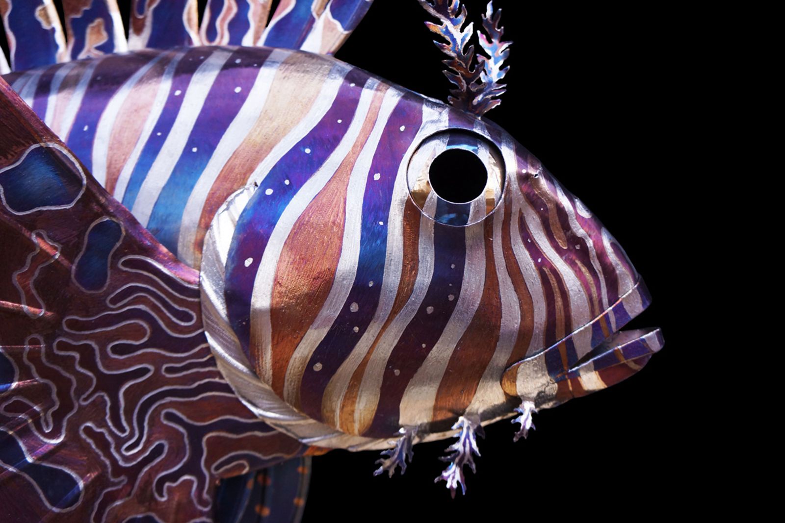 Closeup of metal lionfish sculpture's face.