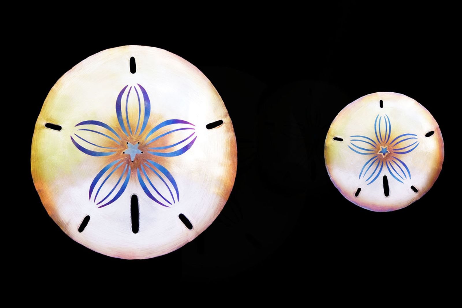 Photo showing two sizes of metal sand dollar sculptures.