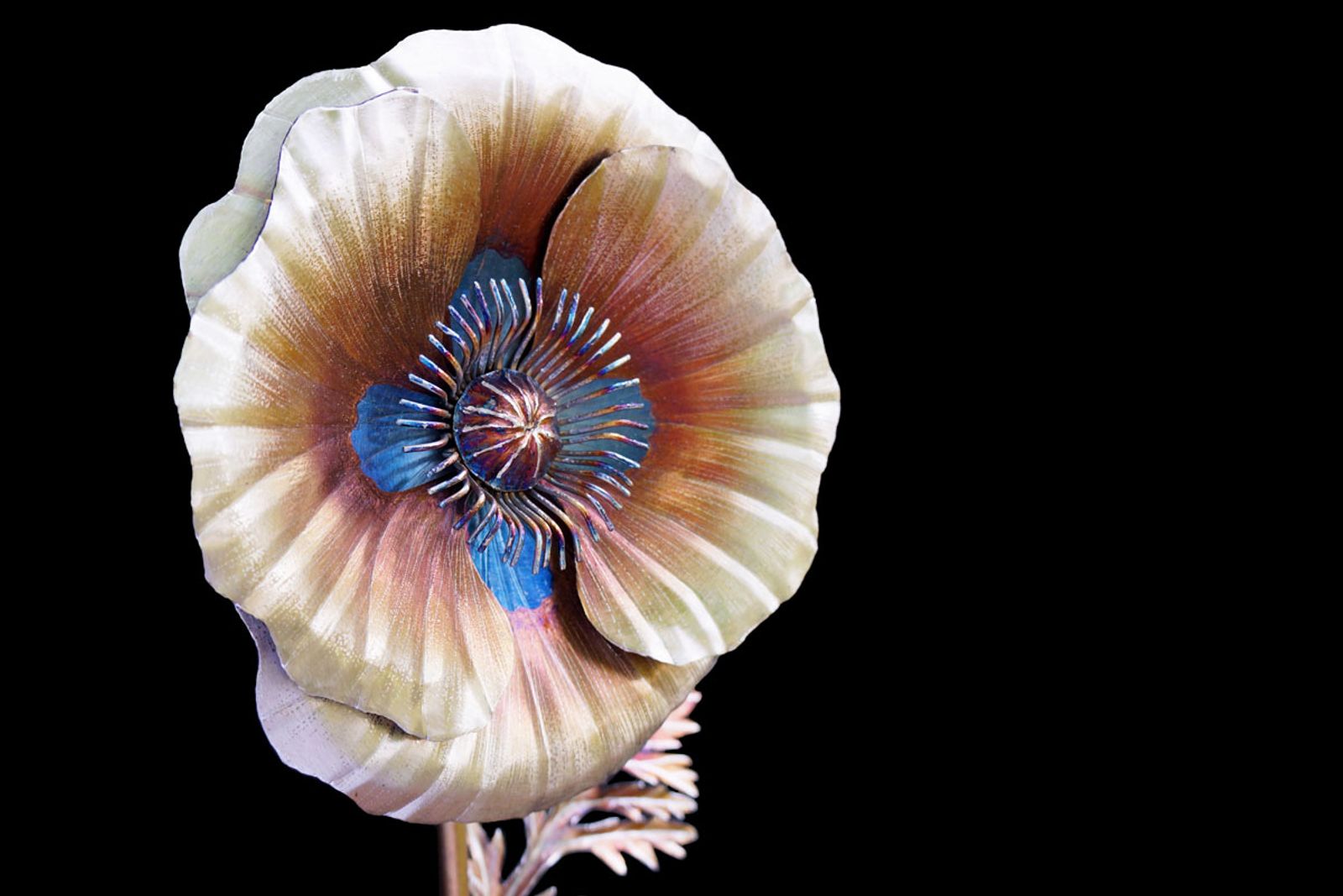 Close-up of stainless steel white poppy bloom showing silver petals, golden details, and intricate blue center adorned with detailed stamen.