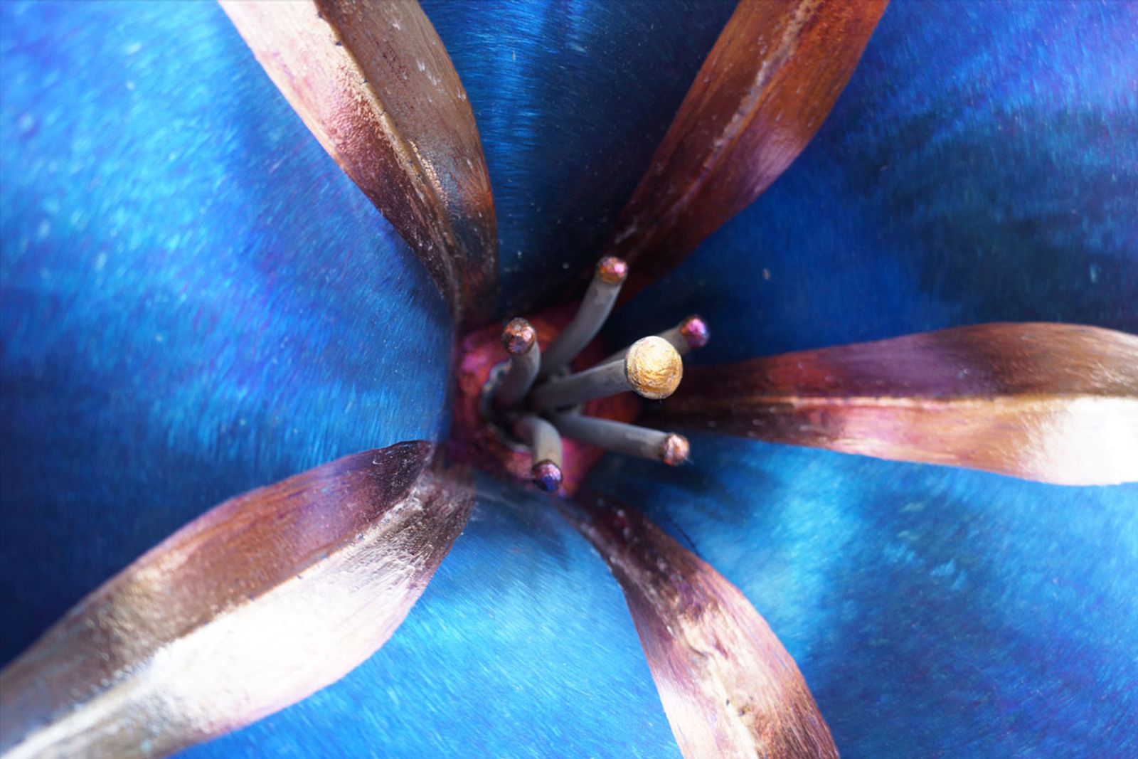 Macro close-up of stainless steel petunia stamen and pistil, hand-bent and ground for lifelike detail in torch-painted metal.