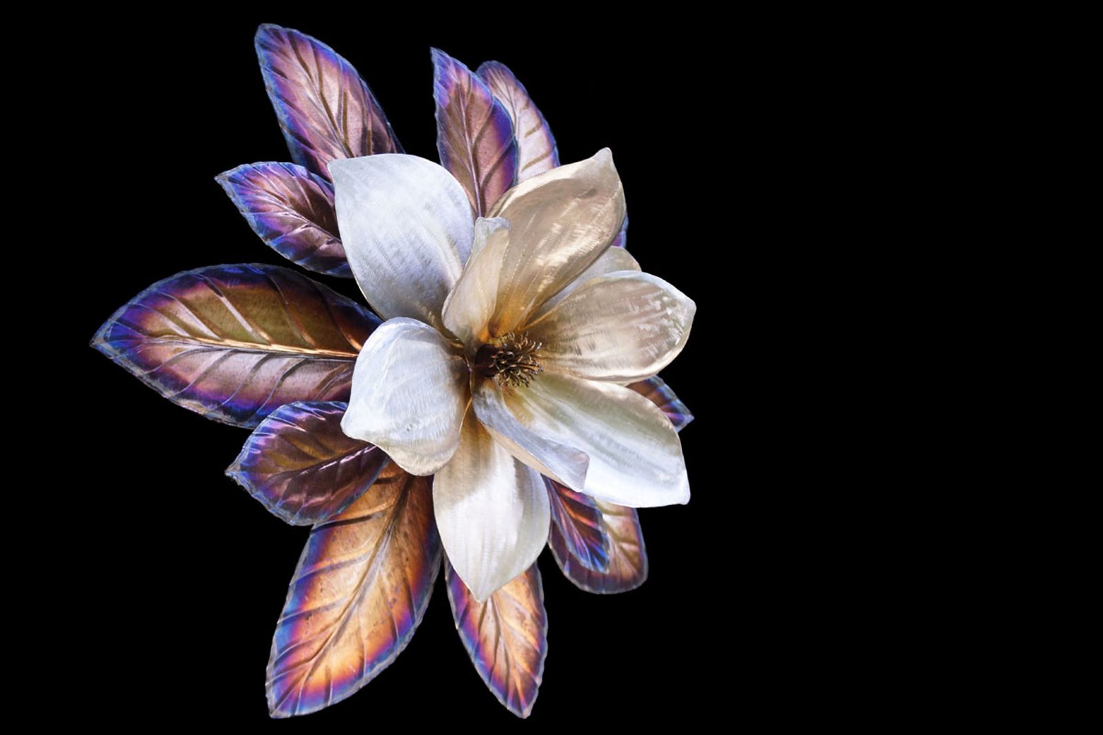 Angled view of stainless steel magnolia wall art, showing depth, layered petals, and three-dimensional form.