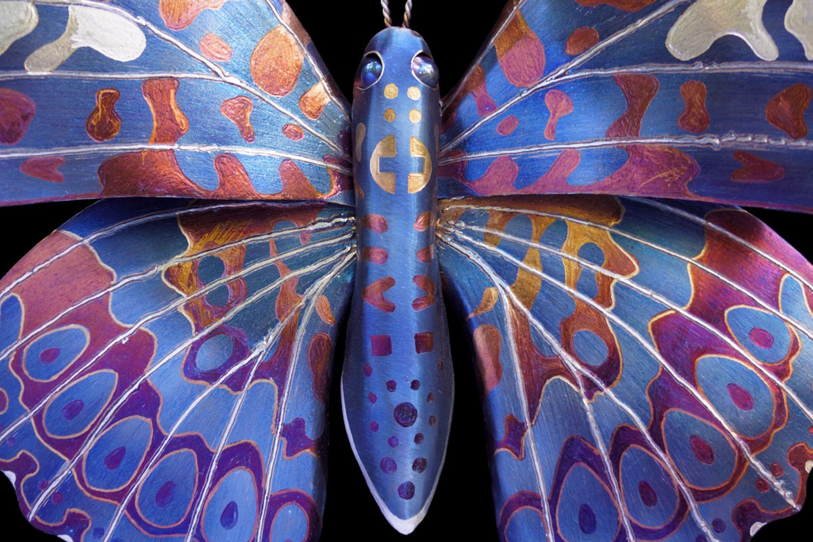 A closer look at the body — ground and shaped until steel feels organic, then flame-painted to catch light like iridescent armor.