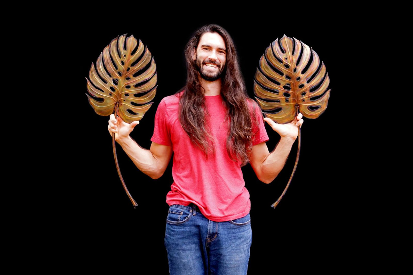 Artist Aiden Dale with metal monstera leaf sculptures