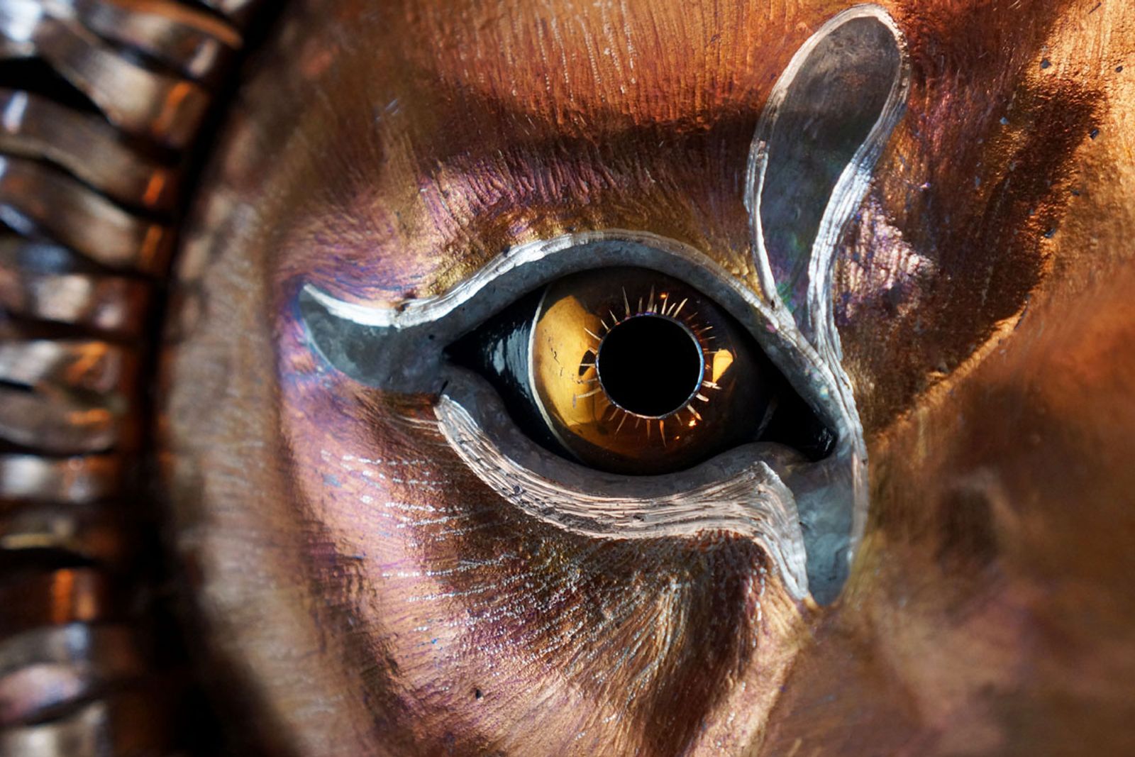 Extreme closeup of stainless steel lion sculpture's eye.