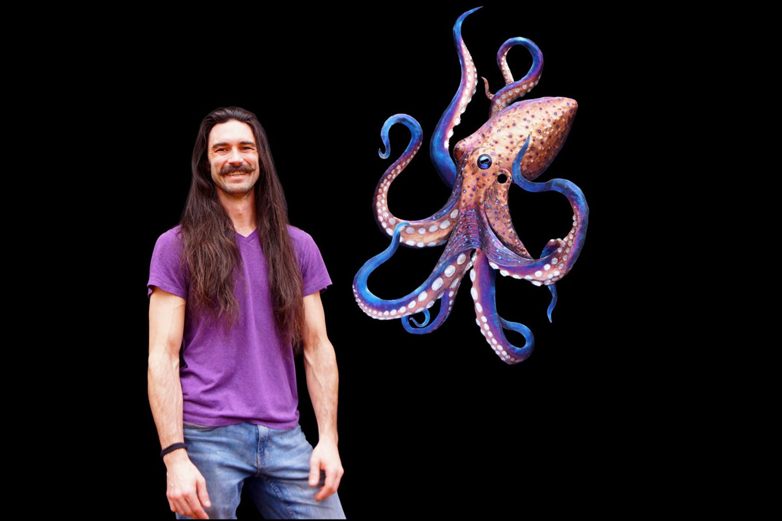 Artist Aiden Dale beside his stainless steel octopus sculpture, handmade with flame patina and intricate grinding work.