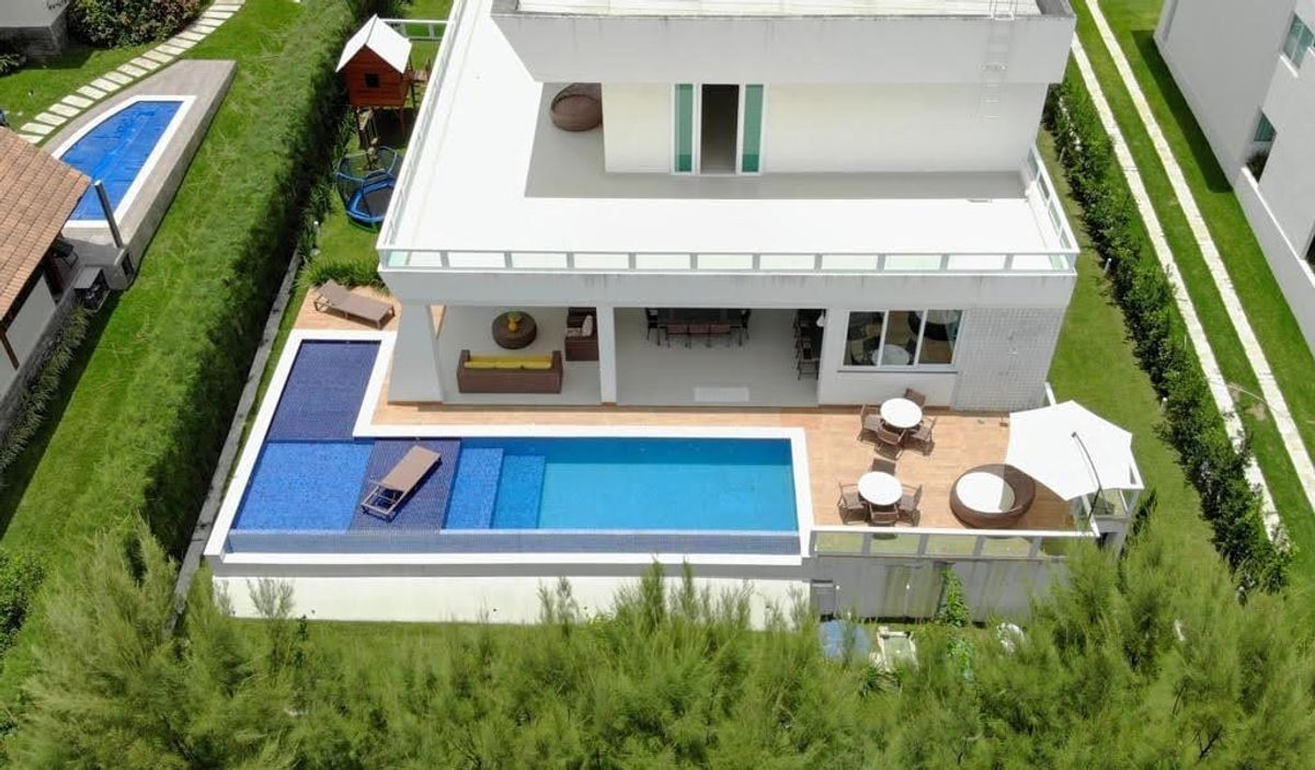 Vista aérea da casa, com piscina, deck e área de lazer integrada ao jardim