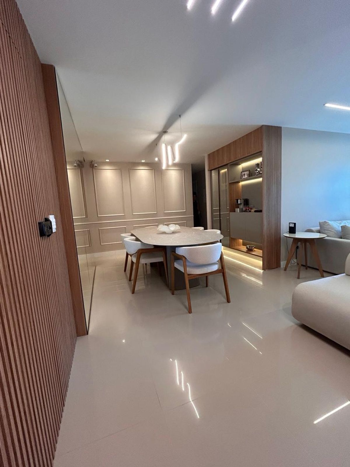 Sala de jantar integrada — mesa oval em mármore e boiserie
