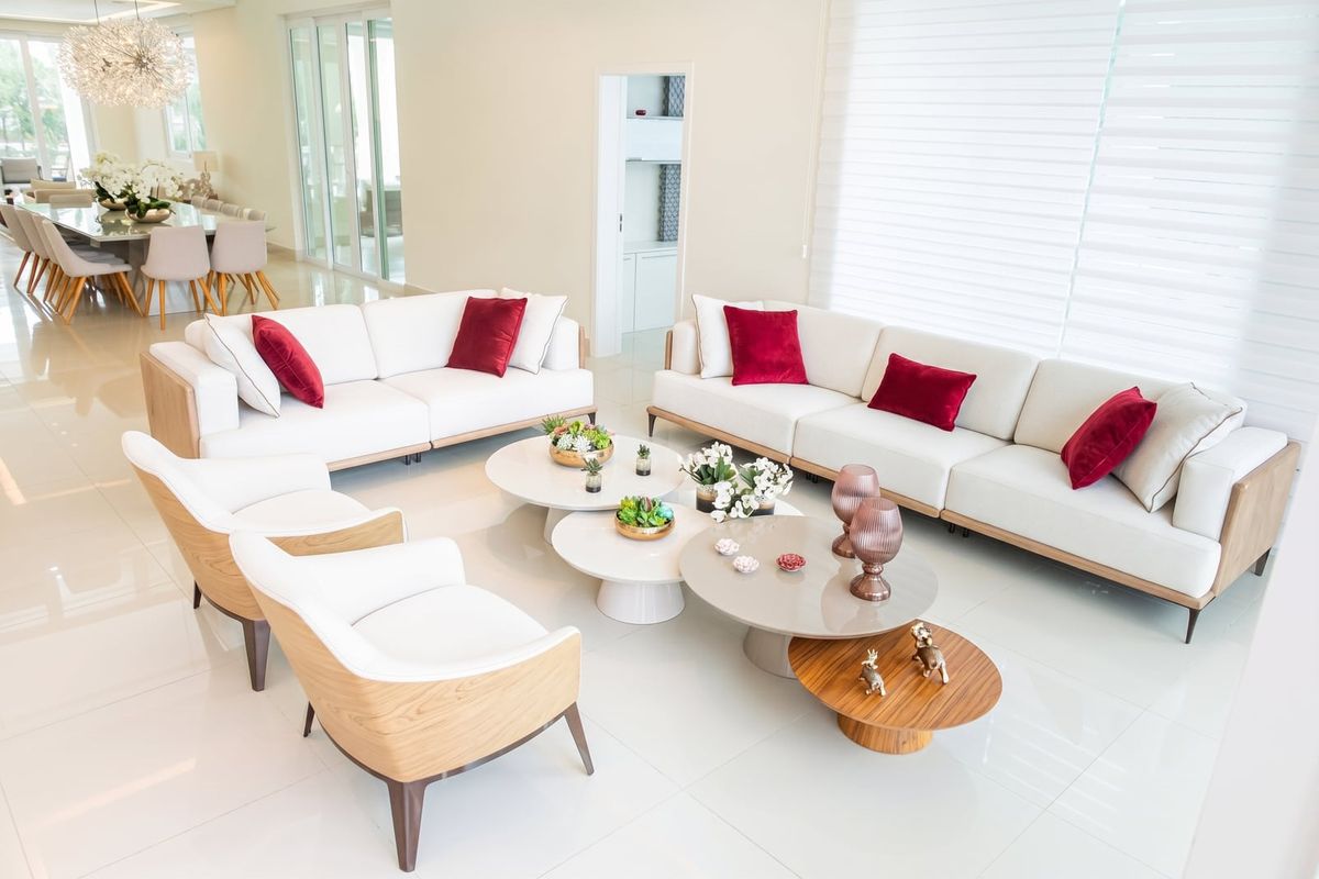 Living amplo com sofás, poltronas e mesas de centro, integrado ao jantar