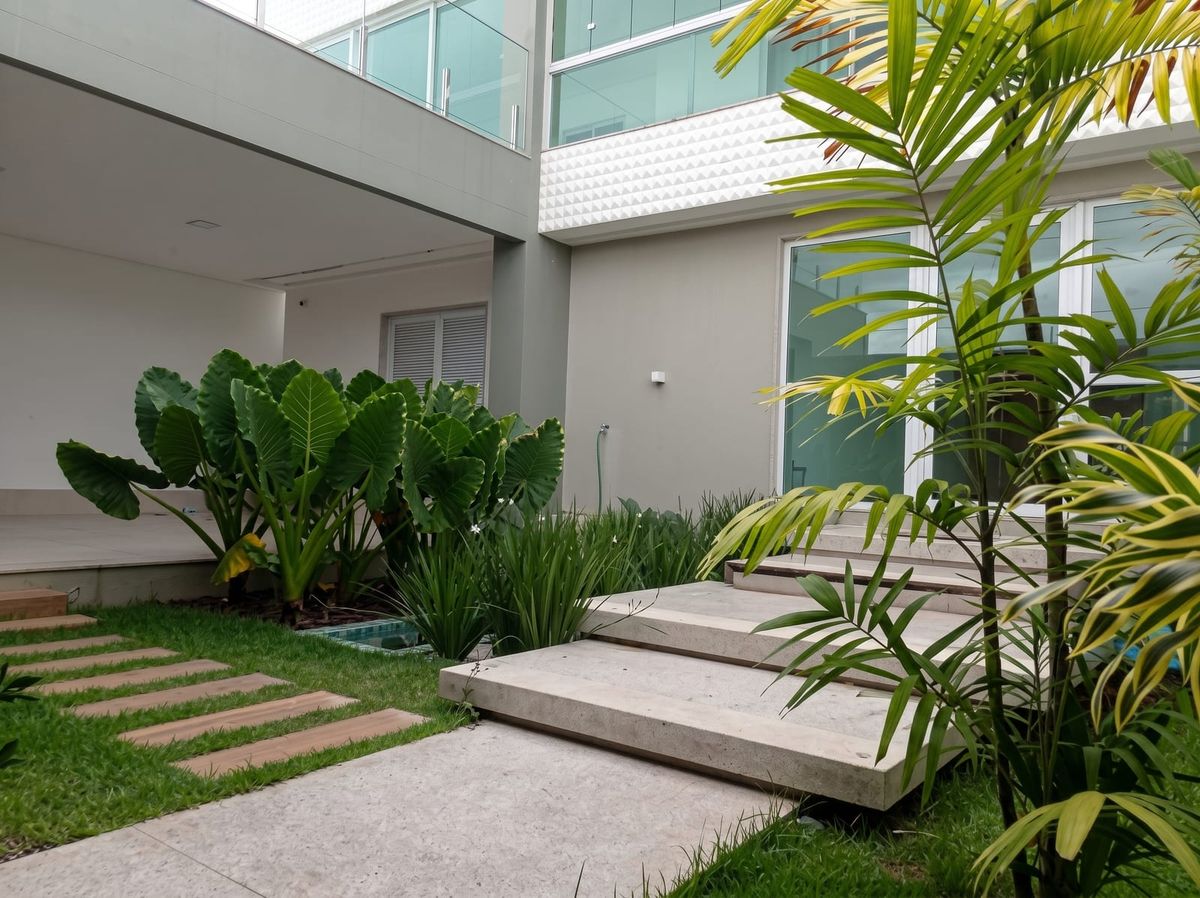 Jardim e acesso lateral com paisagismo tropical