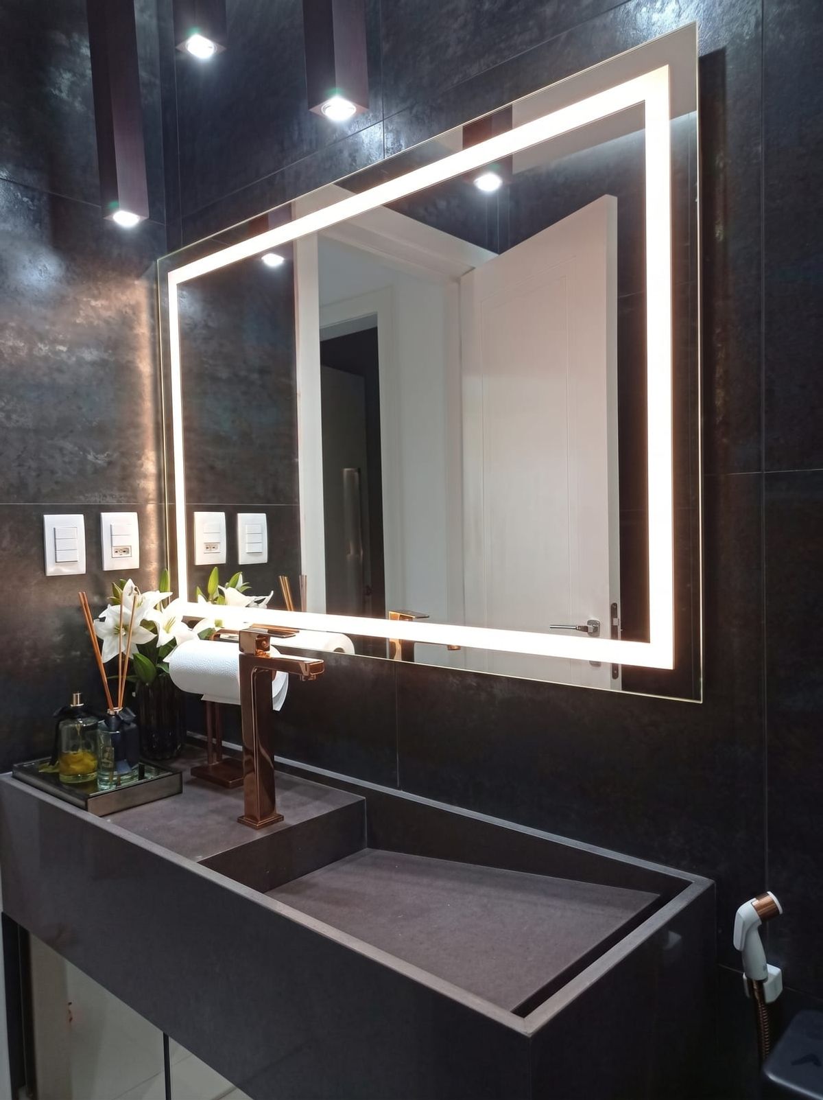 Lavabo com bancada em pedra e espelho iluminado