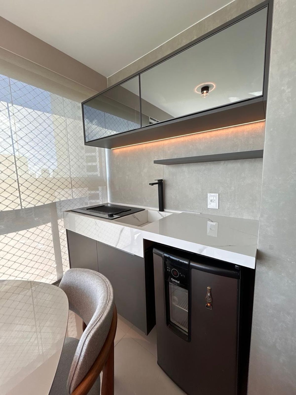 Varanda gourmet — bancada em mármore, cooktop e frigobar