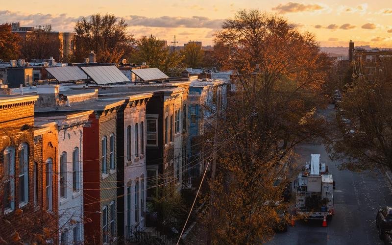 Rooftop solar on a DC rowhouse, with an insurance policy folder on a table