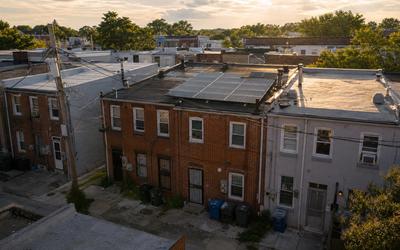 Washington, DC rowhouse block with rooftop solar panels and Pepco lines, illustrating how to pick a local solar company near me