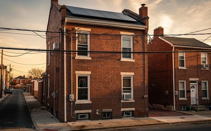 Solar panels on a DC row house roof with Pepco utility lines visible in the background, representing energy companies near me in Washington DC