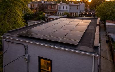 Flat-roof DC rowhouse solar array with light pollen banding and Pepco meter—solar panel maintenance and monitoring services in Washington DC area