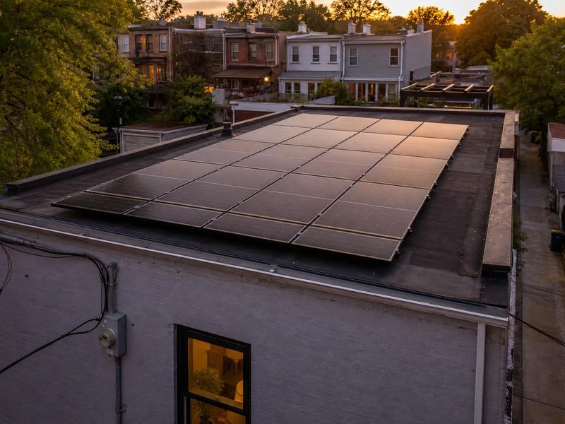 Flat-roof DC rowhouse solar array with light pollen banding and Pepco meter—solar panel maintenance and monitoring services in Washington DC area