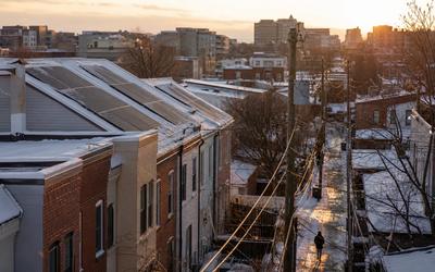 Winter in Washington DC with rowhouse rooftops and solar panels visible after light snowfall, illustrating solar panels working in winter