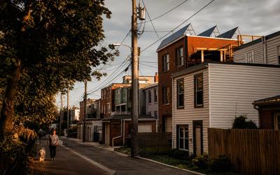 Washington, DC rowhouse block with rooftop solar panels visible, illustrating the shift from Tesla solar tiles to conventional panels
