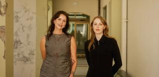 Mikaela Stafford and Kate Durman standing in the cloisters at the NFSA.