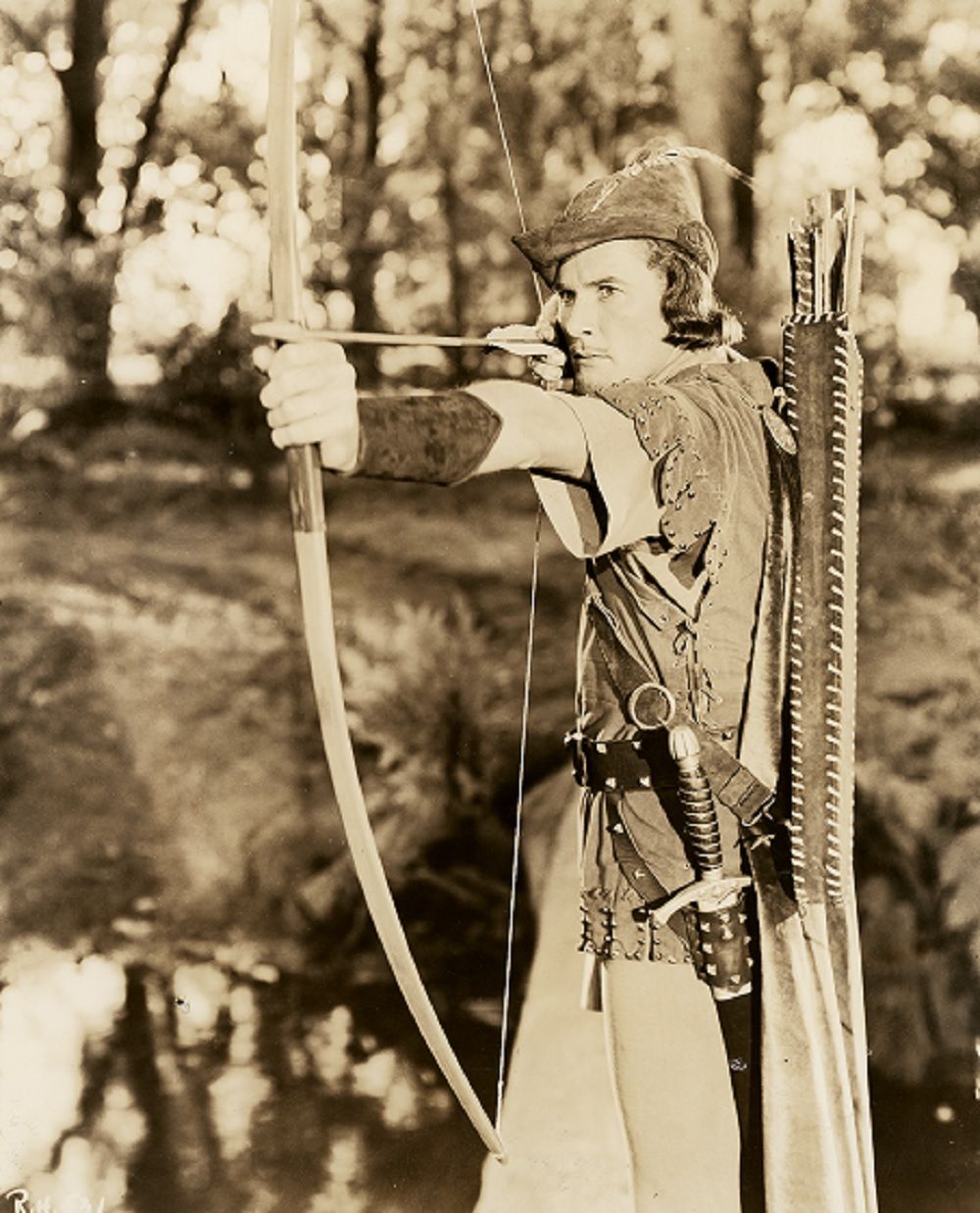 Errol Flynn as Robun Hood sets himself to fire an arrow