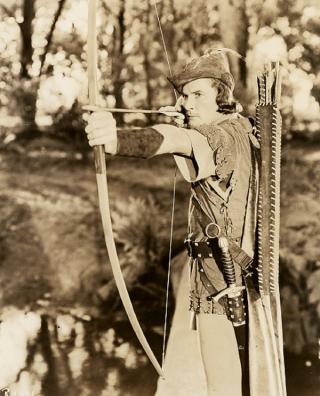 Errol Flynn as Robun Hood sets himself to fire an arrow