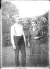 Glass negative of Stuart Booty with his wife in a garden.