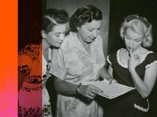 Grace Gibson with two other radio performers looking at a script