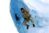 A man hanging from a rope on an icy mountain