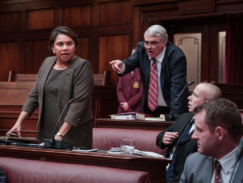 Dramatic scene with a man pointing aggressively at an indigenous woman.