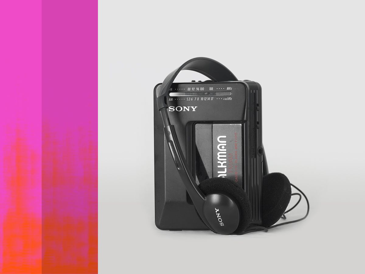 A black Sony Walkman portable radio and cassette player with headphones sitting on top of it.