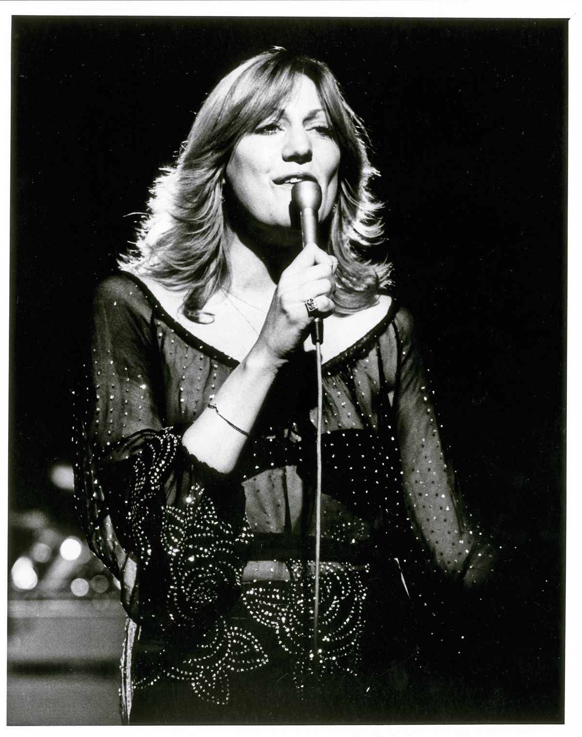 Singer Renee Geyer in a studio singing into a microphone.