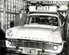 A man standing next to a Holden car with a TV camera mounted on top and a sign for GTV9