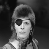 David Bowie wears an eye patch on one eye. He is looking up.