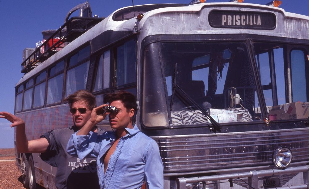 Director Stephan Elliot and Guy Pearce look out across the stony gibber desert with the bus in the background.