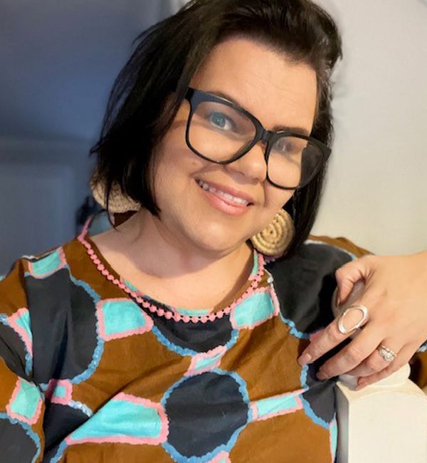 First Nations Engagement Committee member Tasha James leaning against a railing and smiling 