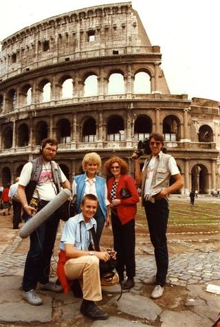 A film crew and reporters from Simon Townsend's Wonder World standing in front of the Colosseum in Rome
