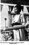 Joyce Mercy stands at a microphone addressing a National Aboriginal Day celebration in 1964