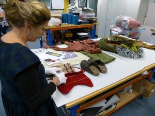Curator Jennifer Gall standing at a table featuring costume artefacts from the NFSA collection.