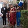 Four women walk towards the camera. One carries an esky.