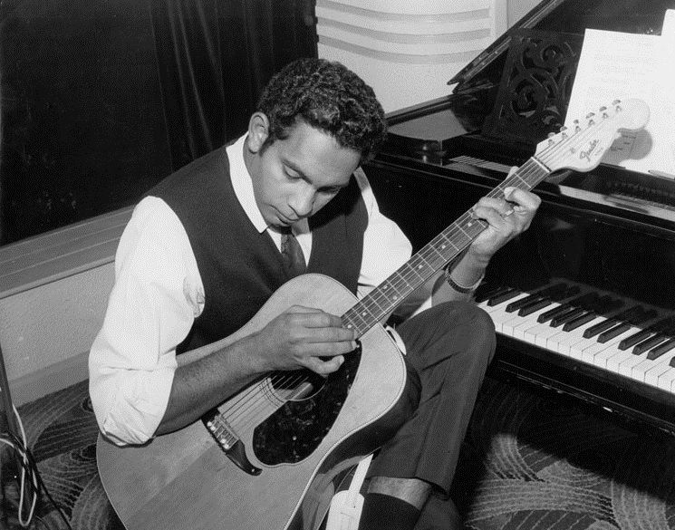 Jimmy Little playing a guitar