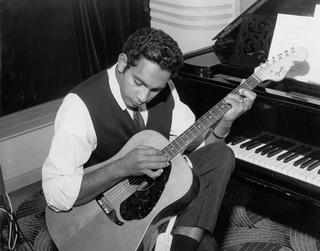 Jimmy Little playing a guitar