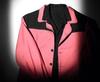 Candy-pink-coloured jacket with black trim on the shoulders and black buttons.