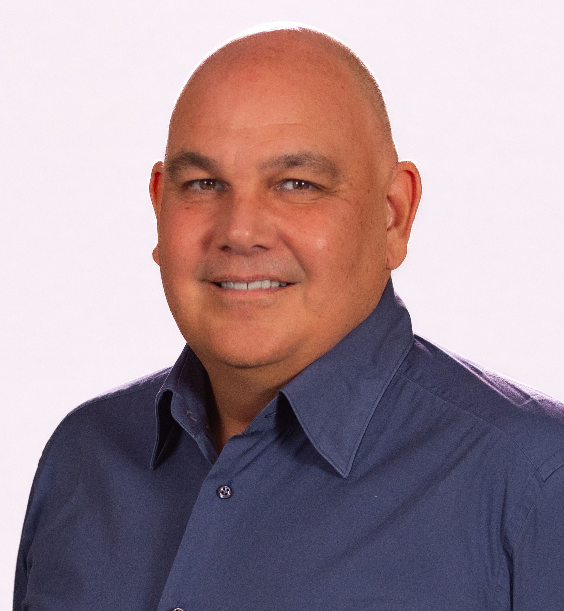 Professor Lyndon Ormond-Parker wearing a blue collared shirt and smiling.