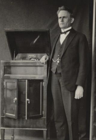 Inventor Stuart Booty in 1925 standing next to a homemade gramophone.