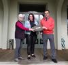 Lindsay Bell and Jan Balgowan stand either side of NFSA Curator Jillian Mackenzie handing her a film in a container.