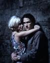 Heath Ledger as Jimmy and Rose Byrne as Alex in a still from Two Hands. The shot is grainy and plays with focus. They are in an embrace while they lean on a wall. Ledger looks at the camera.