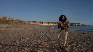 Footage of David Gulpilil on a beach doing a traditional dance in a scene from Storm Boy