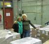 Two NFSA staff members embracing in a room filled with boxes on pallets.